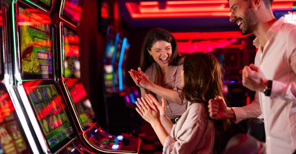 Casino guests celebrating at slot machines, representing strong slot performance and the importance of reliable gaming technology.